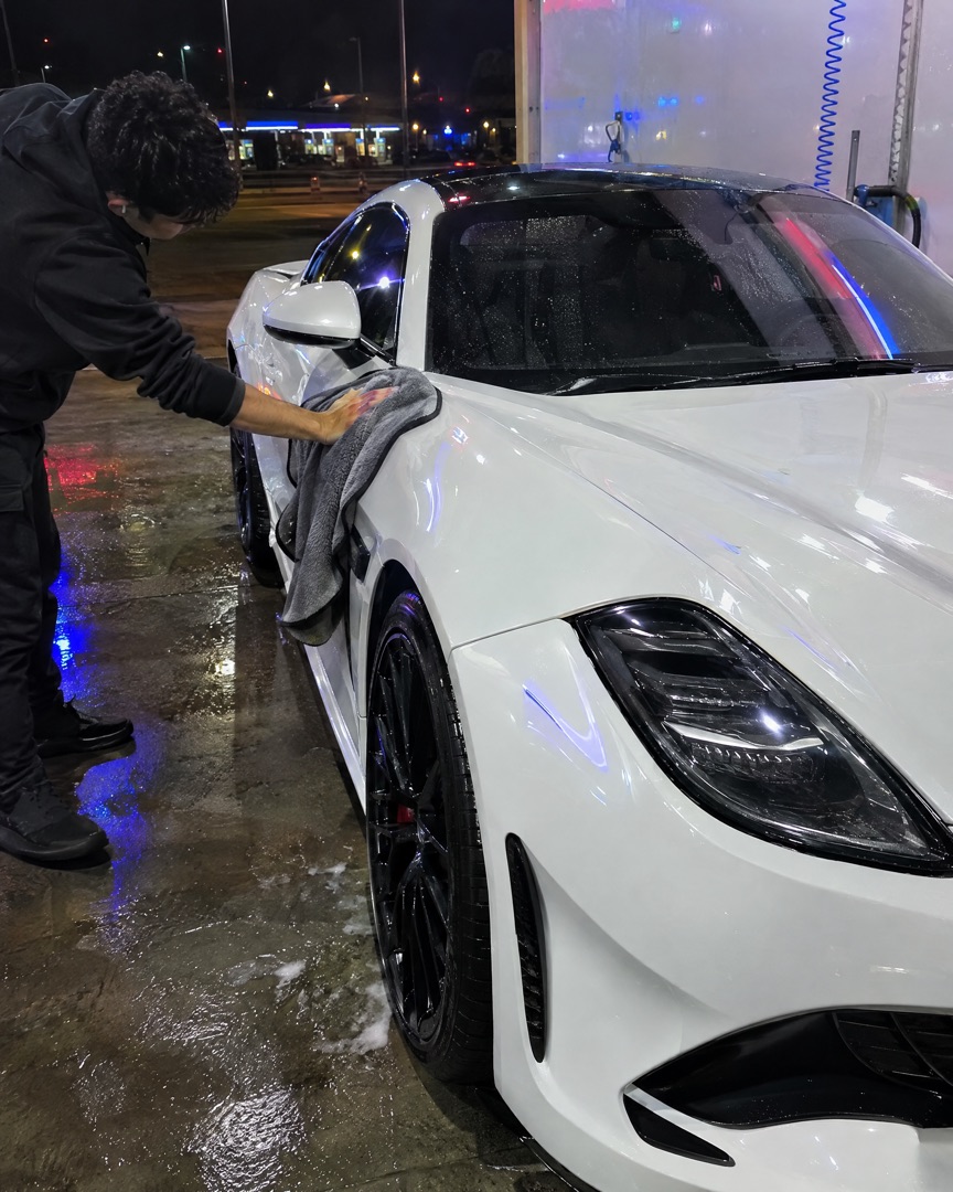 Drying a white sports car at night